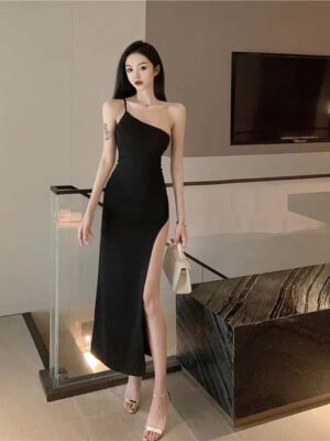 Woman in black one-shoulder midi dress for women party wear, posing with a white handbag